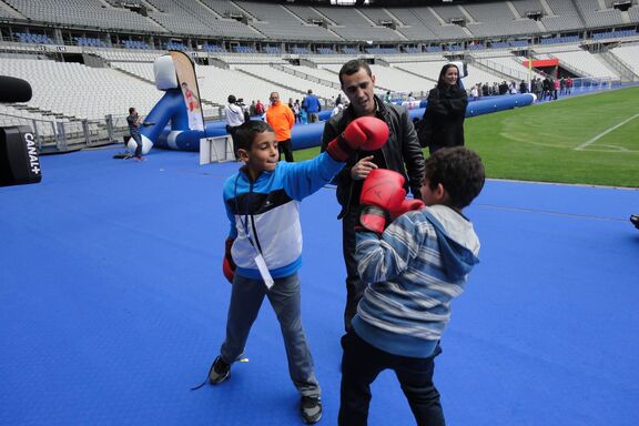 Brahim Asloum done des conseils en boxe à deux enfants du Secours populaire